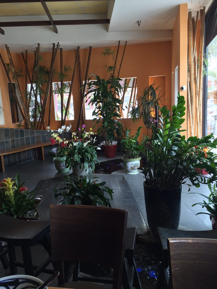 Dining room with potted orchids and bamboo screens